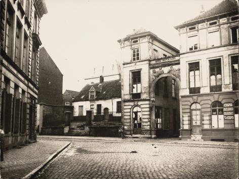 Op de plek van de ingangspoorten van het De Vreesebeluik en het omheinde huisje opent in 1960 het nieuwe gebouw van de faculteit Letteren en Wijsbegeerte (foto begin 20ste eeuw, collectie Universiteitsbibliotheek Gent, © UGent).